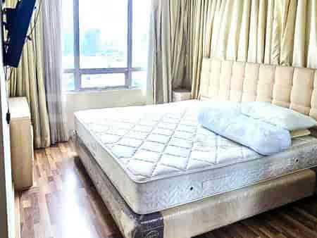 A bedroom with a large bed, city view, and sheer curtains.