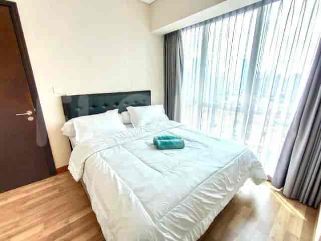 A bedroom with a queen-sized bed, wooden flooring, and a large window.