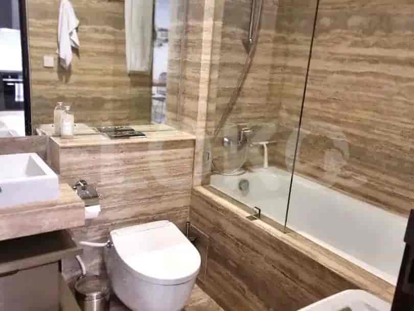 A luxurious bathroom with marble walls and a bathtub.