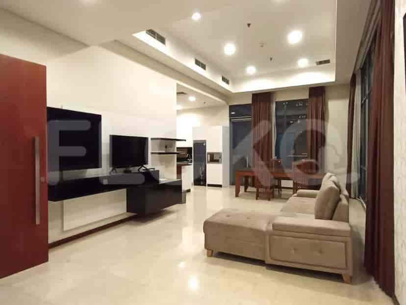 Modern living room with grey sofa, TV, and windows.