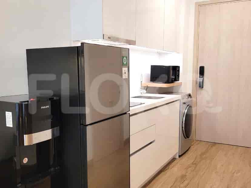 A modern kitchen with white cabinets, stainless steel appliances, and a small refrigerator.