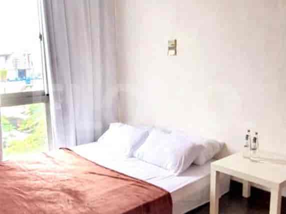 Bedroom with a bed, side table, and a window.