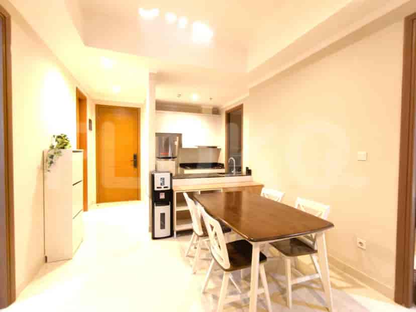 An open-concept kitchen and dining area with a wooden dining table and white cabinets.