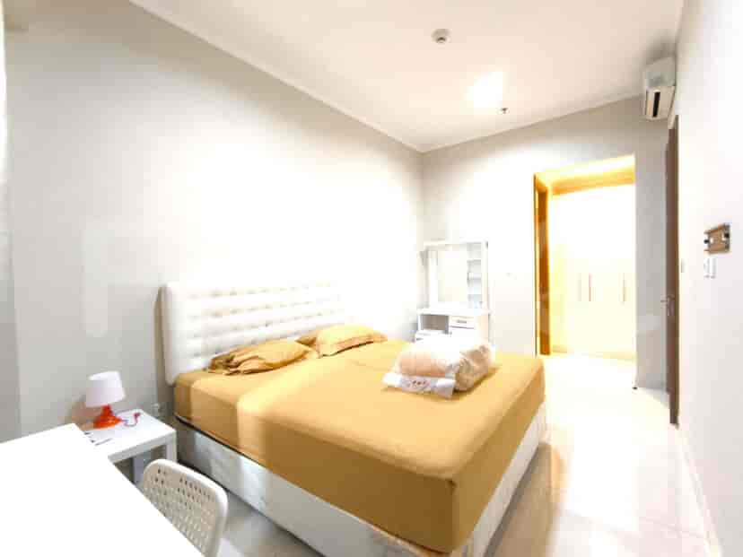 A modern bedroom with a bed, side tables, and a dressing table.