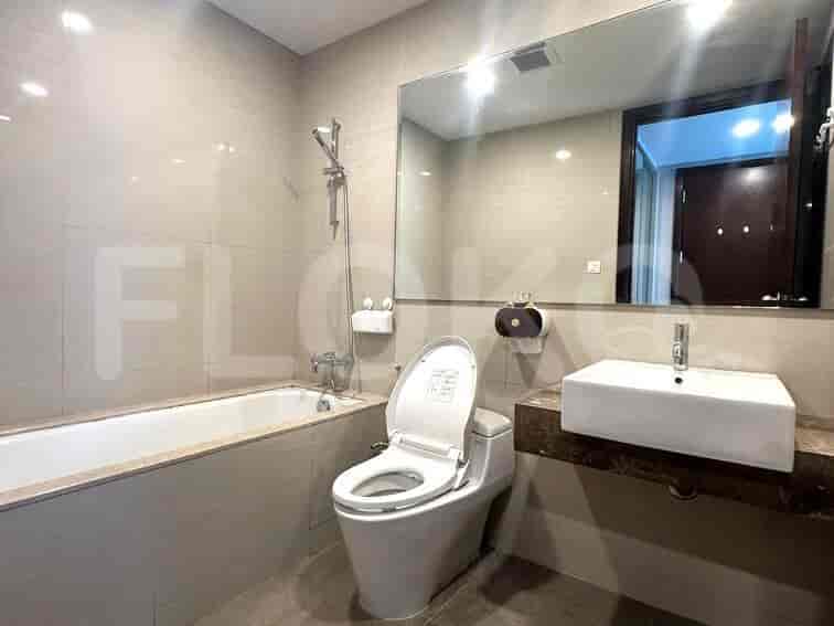 Modern bathroom with a bathtub, a toilet, and a large mirror.