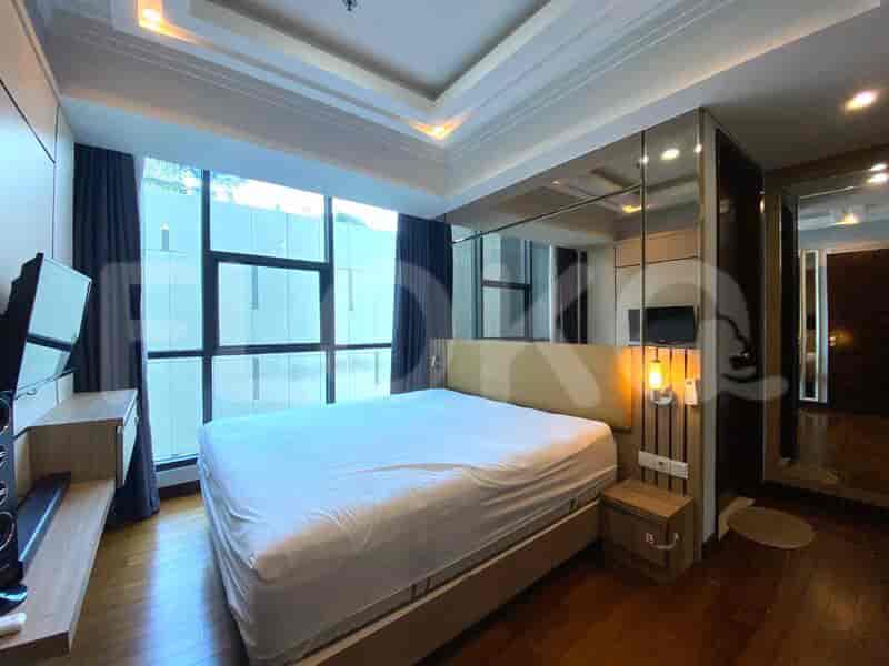 A well-appointed bedroom featuring a large bed, mirror, and wooden flooring.