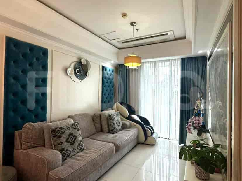 A modern living room with a grey sofa, accent wall, and large window.