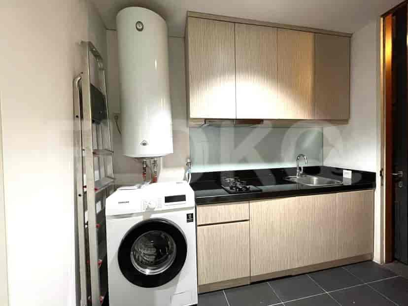 Small kitchen with a washing machine, cabinets, and stove.