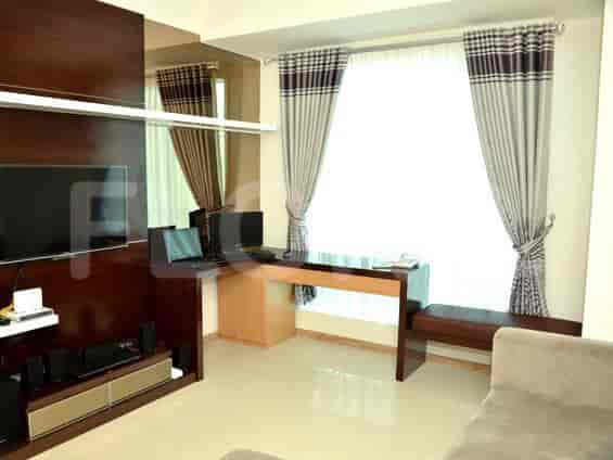 Tata letak ruang tamu modern dengan meja built-in, TV, dan jendela besar.