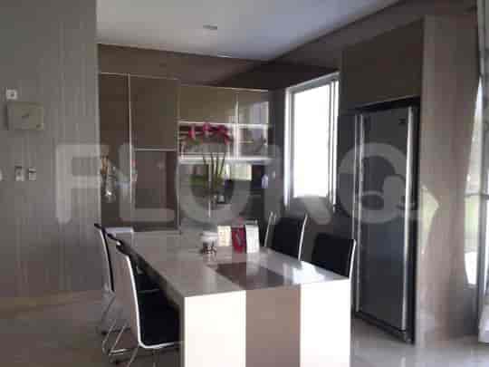 A dining area with a table, chairs, and a refrigerator.