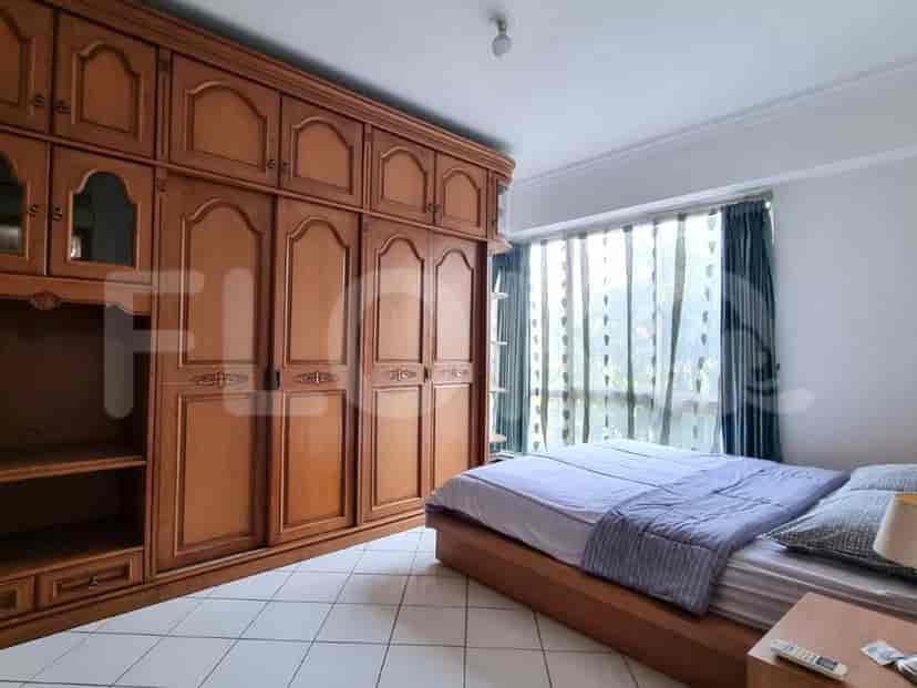 Kamar tidur yang nyaman dengan lemari kayu besar dan tempat tidur ukuran queen dengan gorden.