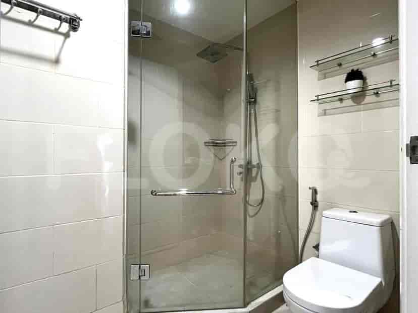 A modern bathroom with a glass shower enclosure and a white toilet.