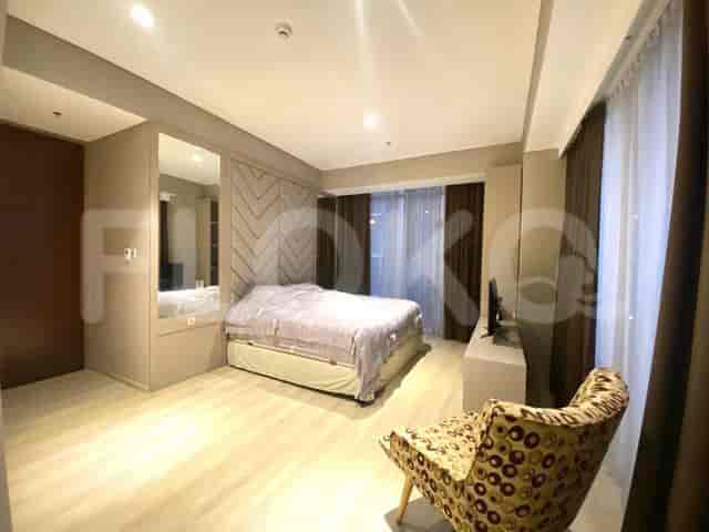 Kamar tidur yang menampilkan tempat tidur ganda, kursi, dan TV.