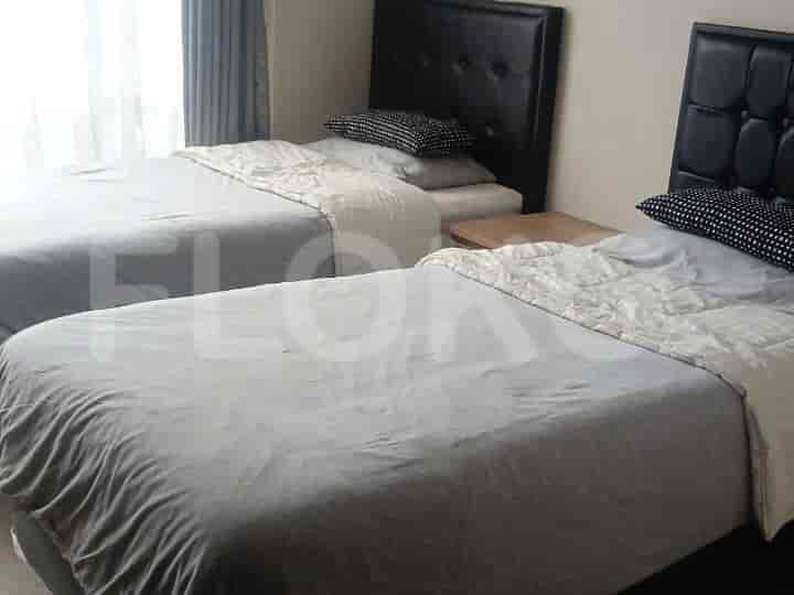 Two twin beds with a nightstand between them.