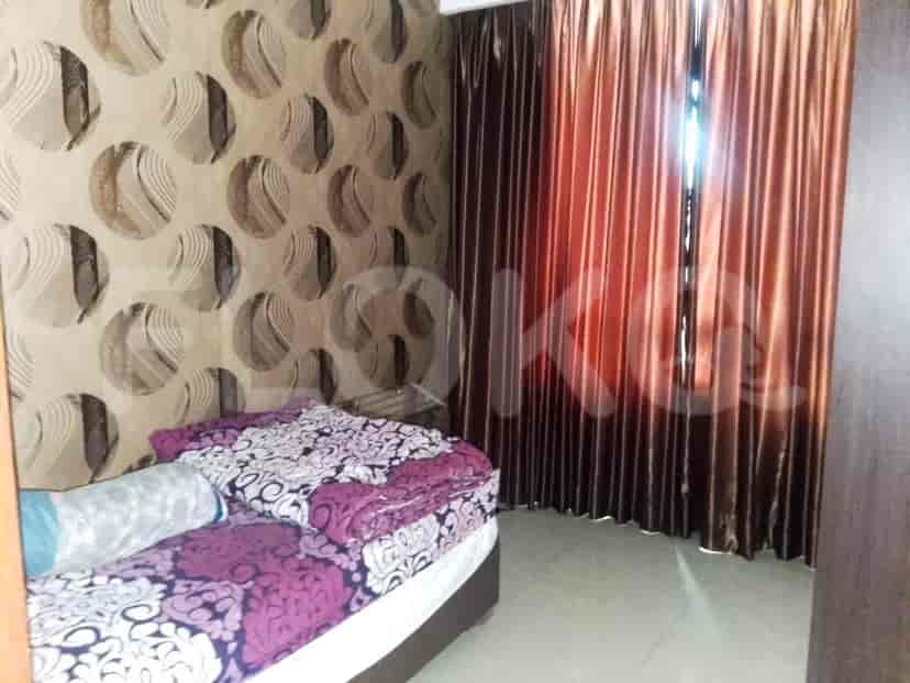 A bedroom with a bed, curtains, and decorative wallpaper.
