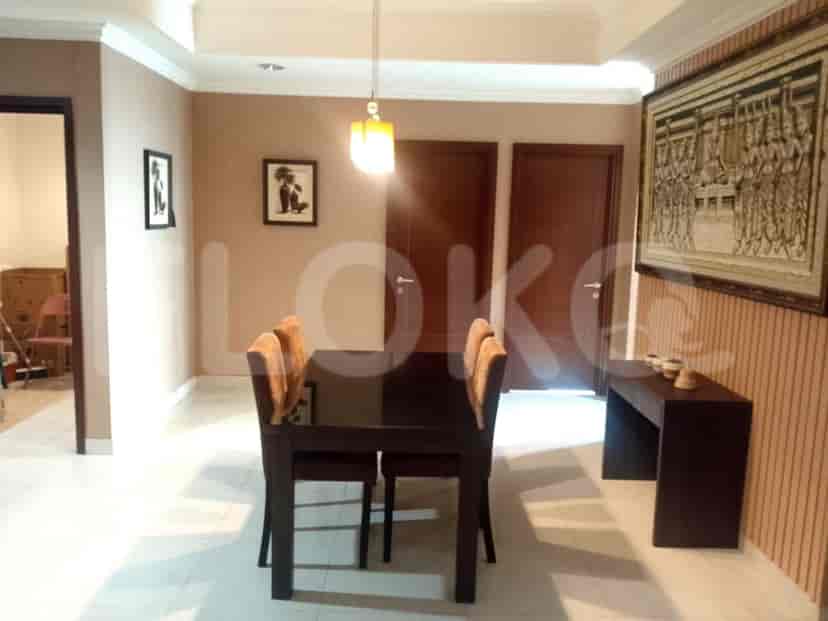 Dining area with a wooden table and chairs, decorated with artwork and a pendant light.