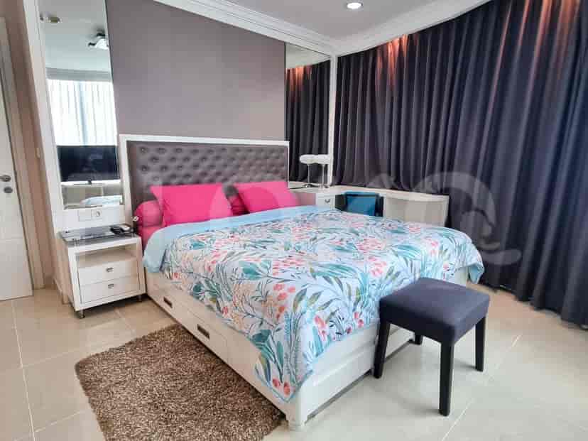 A well-appointed bedroom with a large bed, a mirrored wall, and dark curtains.
