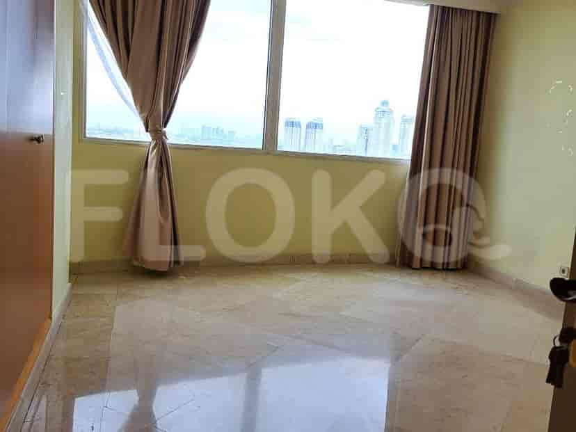 A bedroom with large windows and curtains.