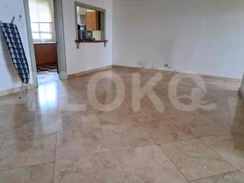 Empty living room with marble flooring and a view of a kitchen area.
