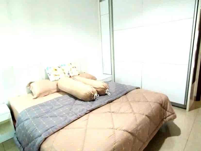 A bedroom with a bed, a wardrobe, and a bedside table.