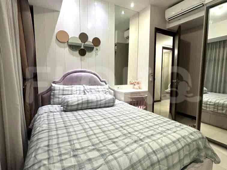 Kamar tidur yang menampilkan tempat tidur, meja rias dengan cermin, dan cermin bundar.