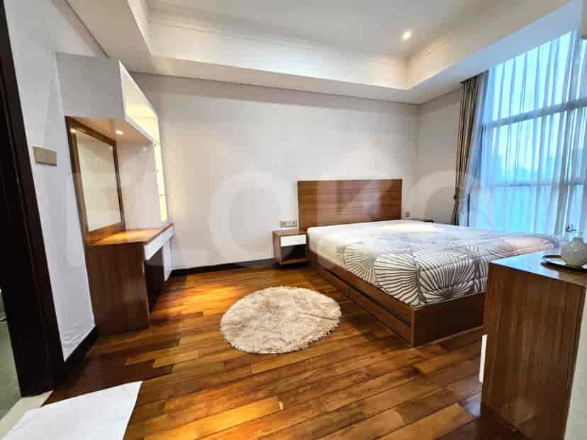 A bedroom with a wooden bed, round rug, and vanity table.