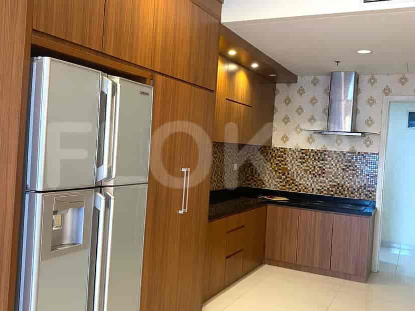 Dapur dengan lemari kayu, kulkas, dan backsplash.
