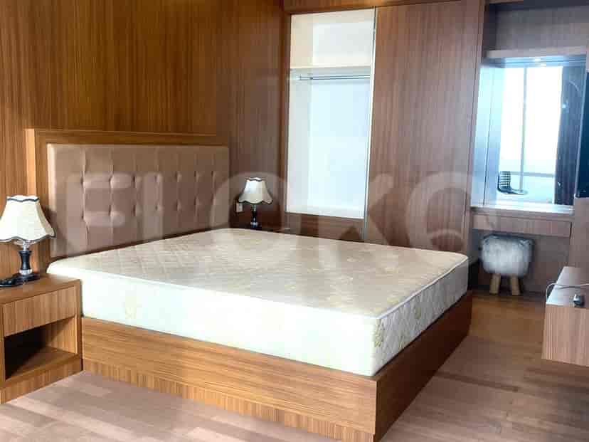 Kamar tidur dengan tempat tidur ganda, perabotan kayu, dan jendela besar.