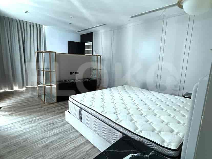 Kamar tidur modern dengan tempat tidur ukuran queen dan penyimpanan built-in.