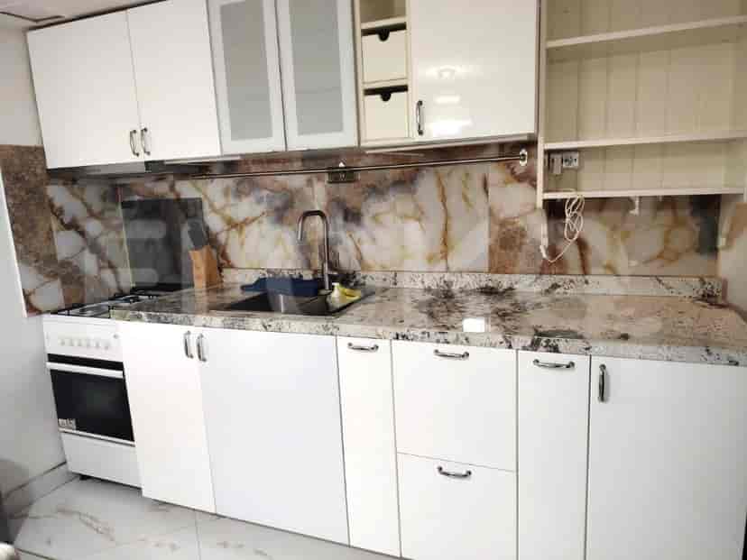 Dapur yang menampilkan lemari dan meja putih.