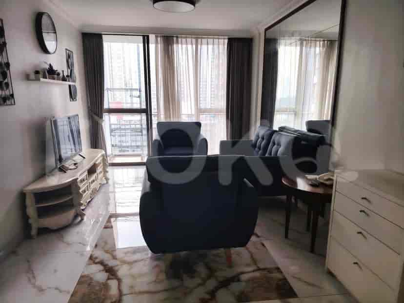 Ruang tamu dengan sofa, TV, dan pemandangan dari jendela.
