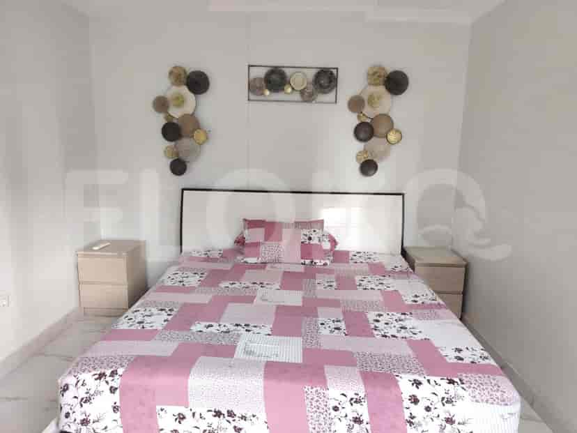 Kamar tidur dengan tempat tidur, meja samping tempat tidur, dan dekorasi dinding.