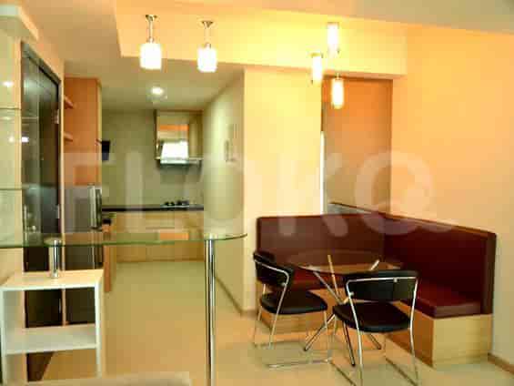Dapur dan area makan yang ringkas dengan meja kaca dan tempat duduk built-in.