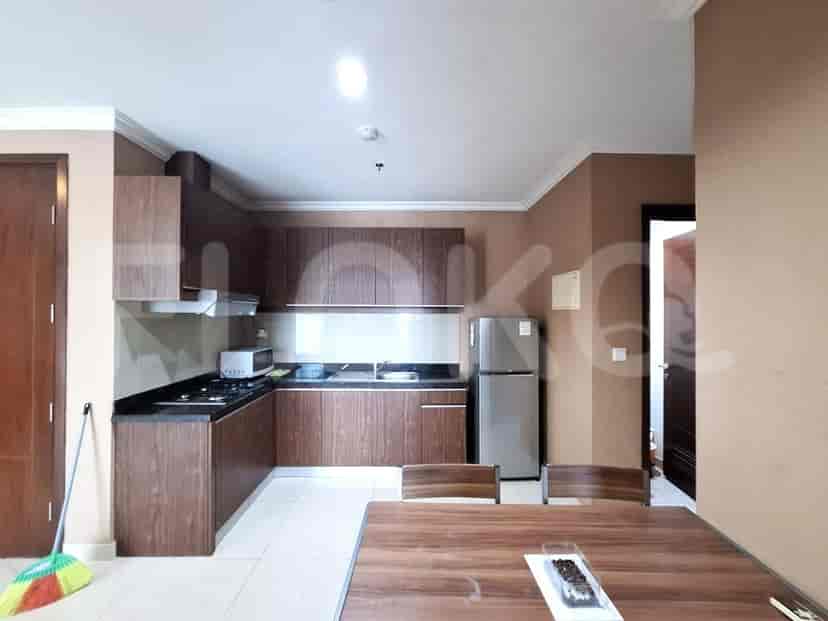 A well-equipped kitchen with wooden cabinets, a stainless steel refrigerator, and a dining table.