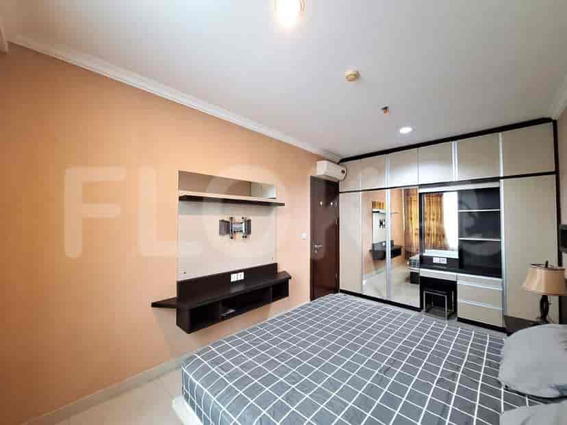 A modern bedroom featuring a bed with a patterned duvet, a wall-mounted TV setup, and a built-in closet.