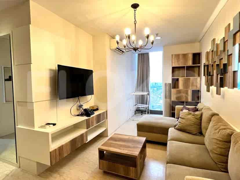 A living room with an L-shaped sofa, TV, and coffee table.