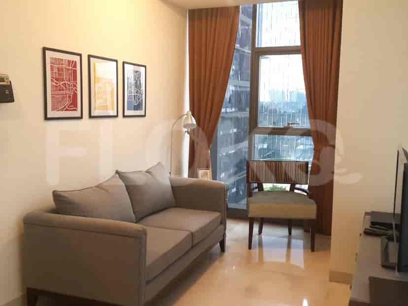 A cozy living room with a grey sofa, art, and a window offering a city view.