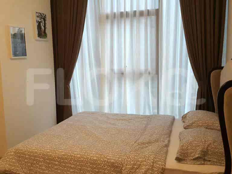 A bedroom with a bed and sheer curtains.
