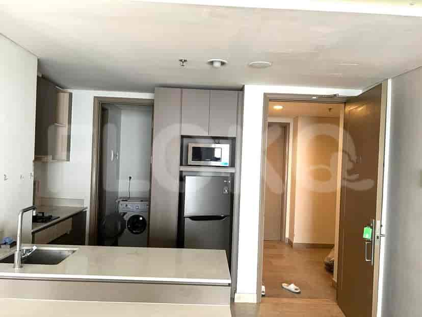 Modern kitchen with refrigerator, microwave and laundry.