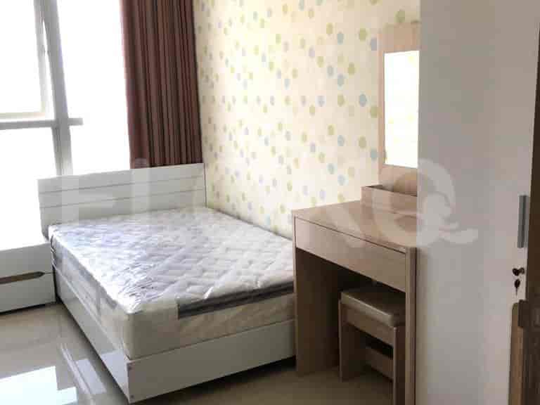 A bedroom with a bed and a vanity area.