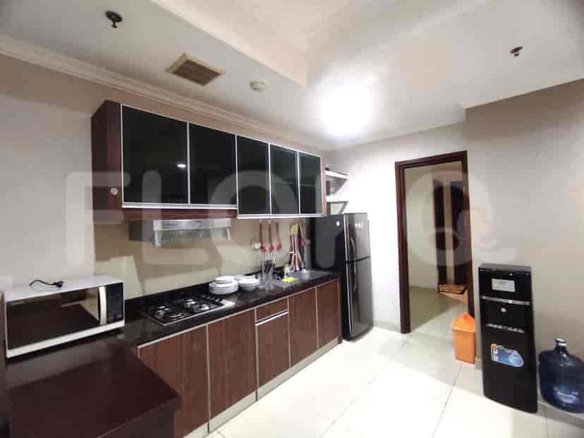 A kitchen featuring dark wood cabinets, a gas stove, and a refrigerator.