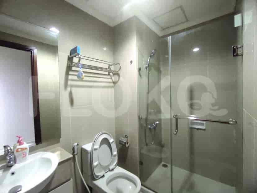 A bathroom with a glass shower enclosure and a toilet.