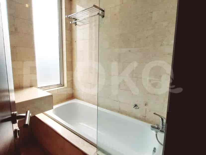 Elegant bathroom with a bathtub and stone wall accents.