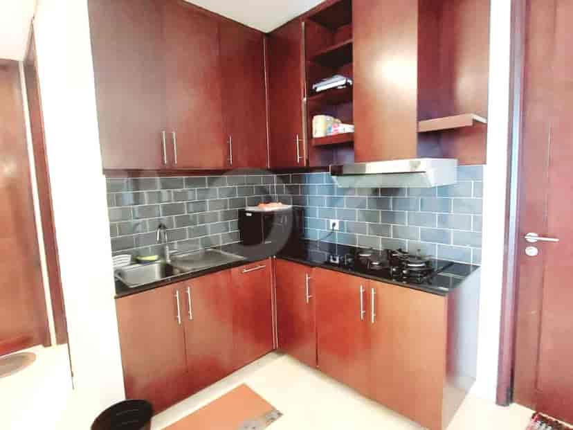 Compact kitchen with wooden cabinets and basic appliances.