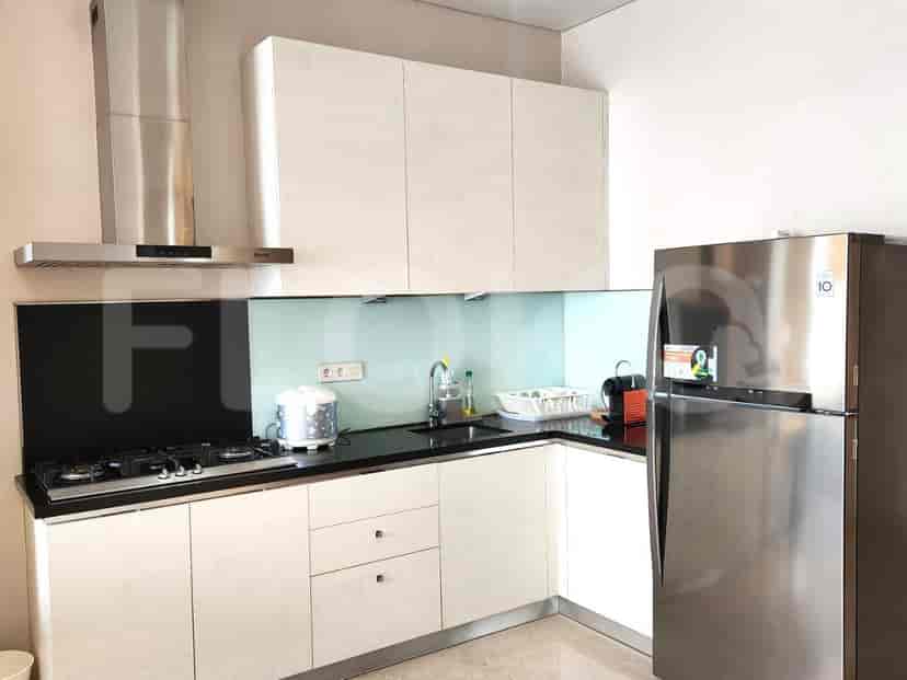 Dapur modern dengan lemari putih, peralatan stainless steel, dan meja hitam.