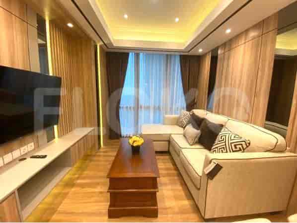 Modern living room with a sectional sofa, TV, and large windows.