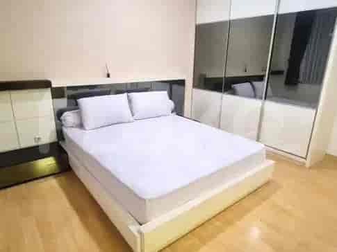 Kamar tidur yang terang dengan tempat tidur putih dan lemari cermin besar.