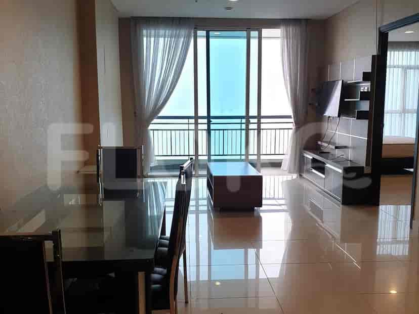 Ruang tamu modern dengan ruang makan, TV, dan akses balkon.