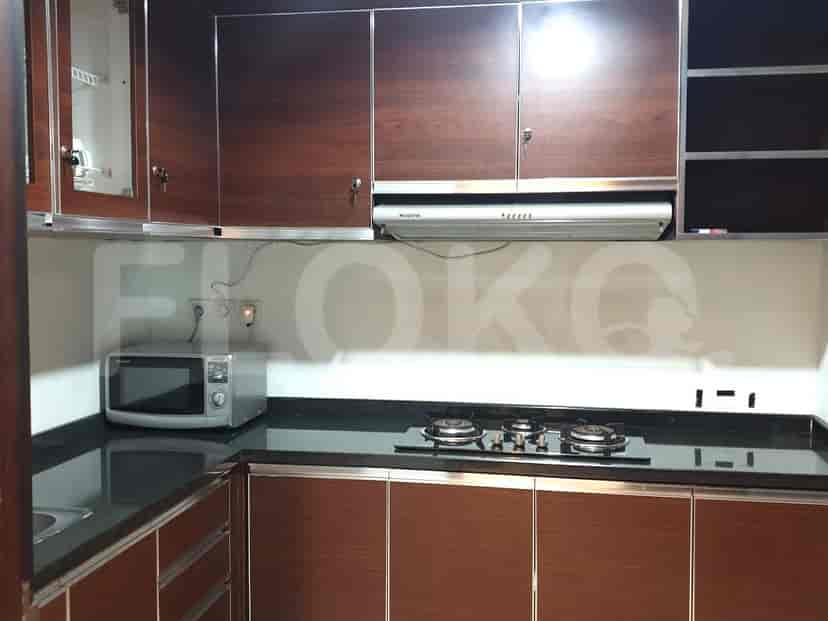 Dapur modern dengan microwave, kompor gas, dan lemari kayu.