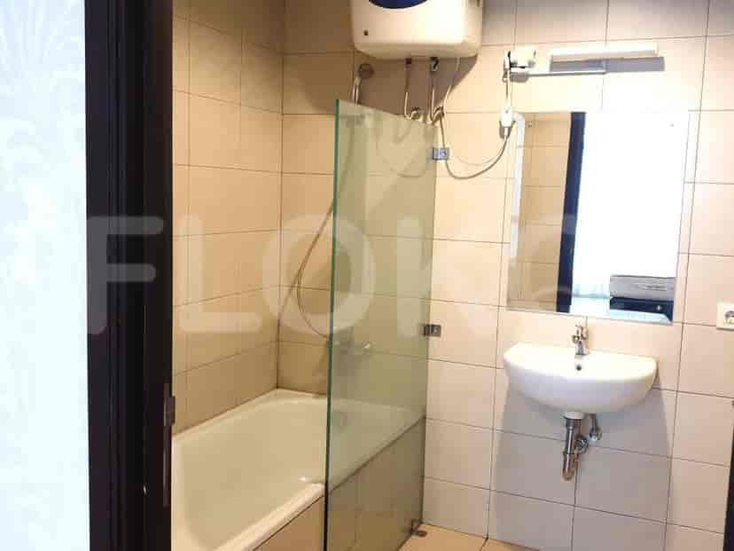 Kamar mandi dengan wastafel, bak mandi, dan layar pancuran kaca.